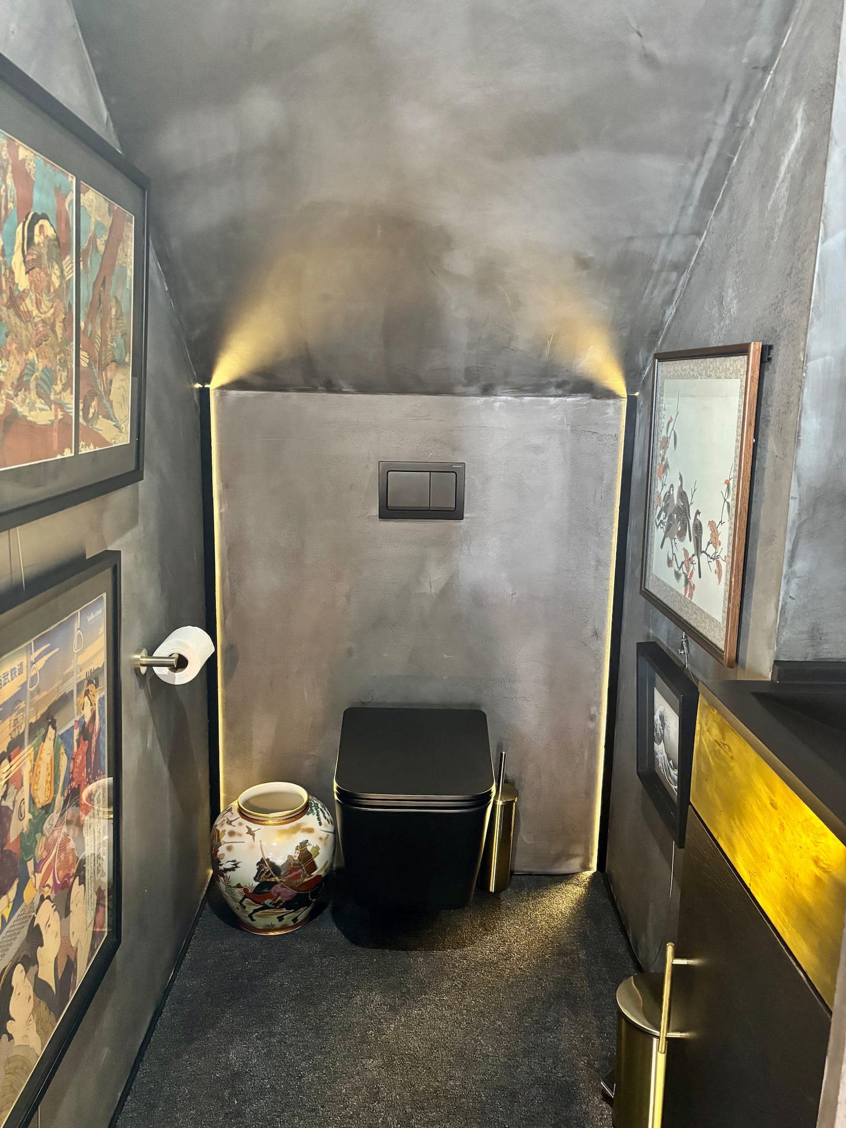 Powder room with a black WC, concrete walls and framed art