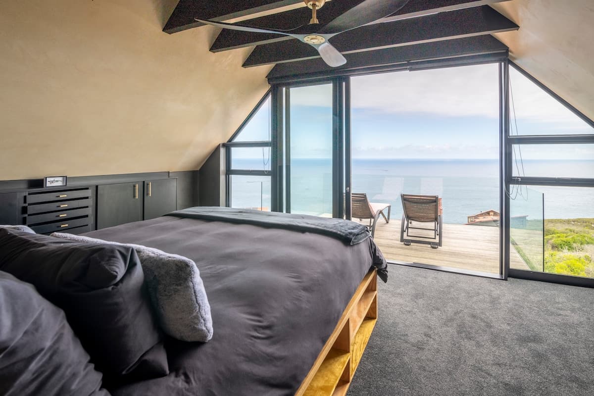 Bedroom with floor-to-ceiling windows and ocean view