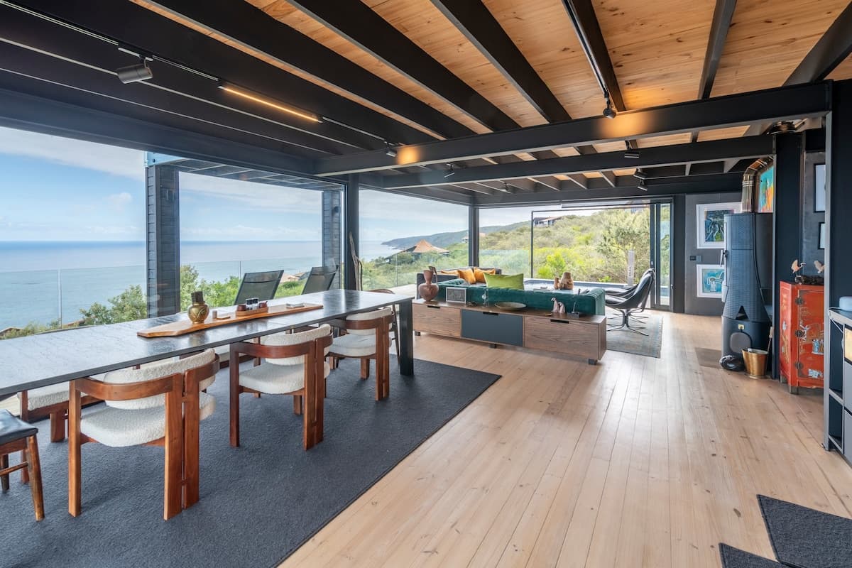 Open-plan living and dining area opening onto the deck and ocean