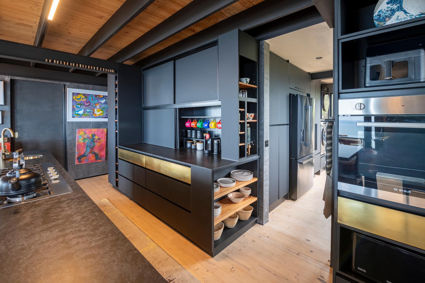 Kitchen island with open oak shelving, crockery and a mug rack