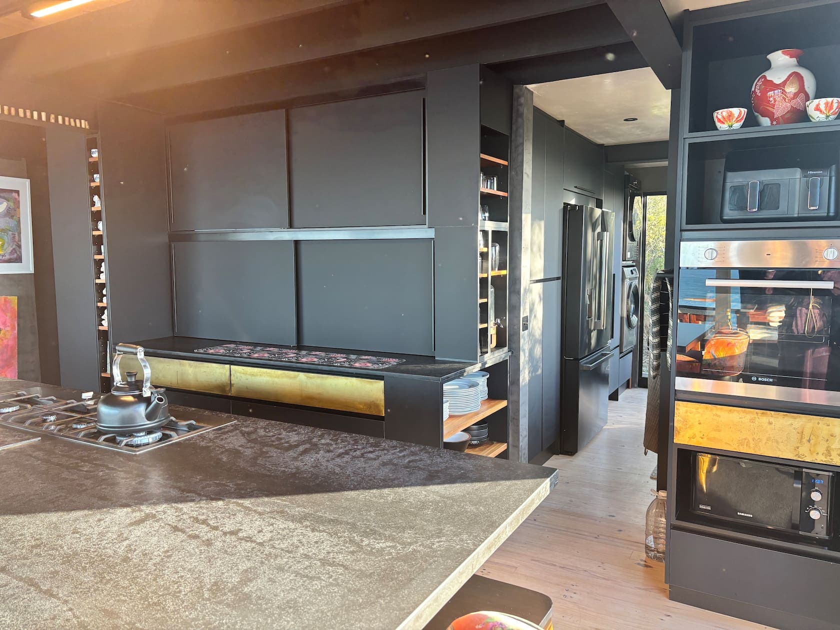 Cooking zone with a gas cooktop, built-in ovens and a scullery beyond