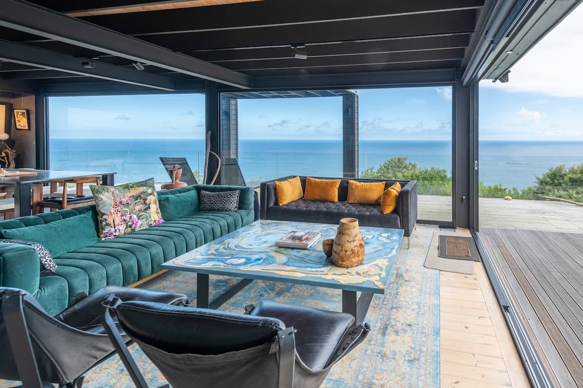 Lounge with velvet sofas framing a panoramic ocean view